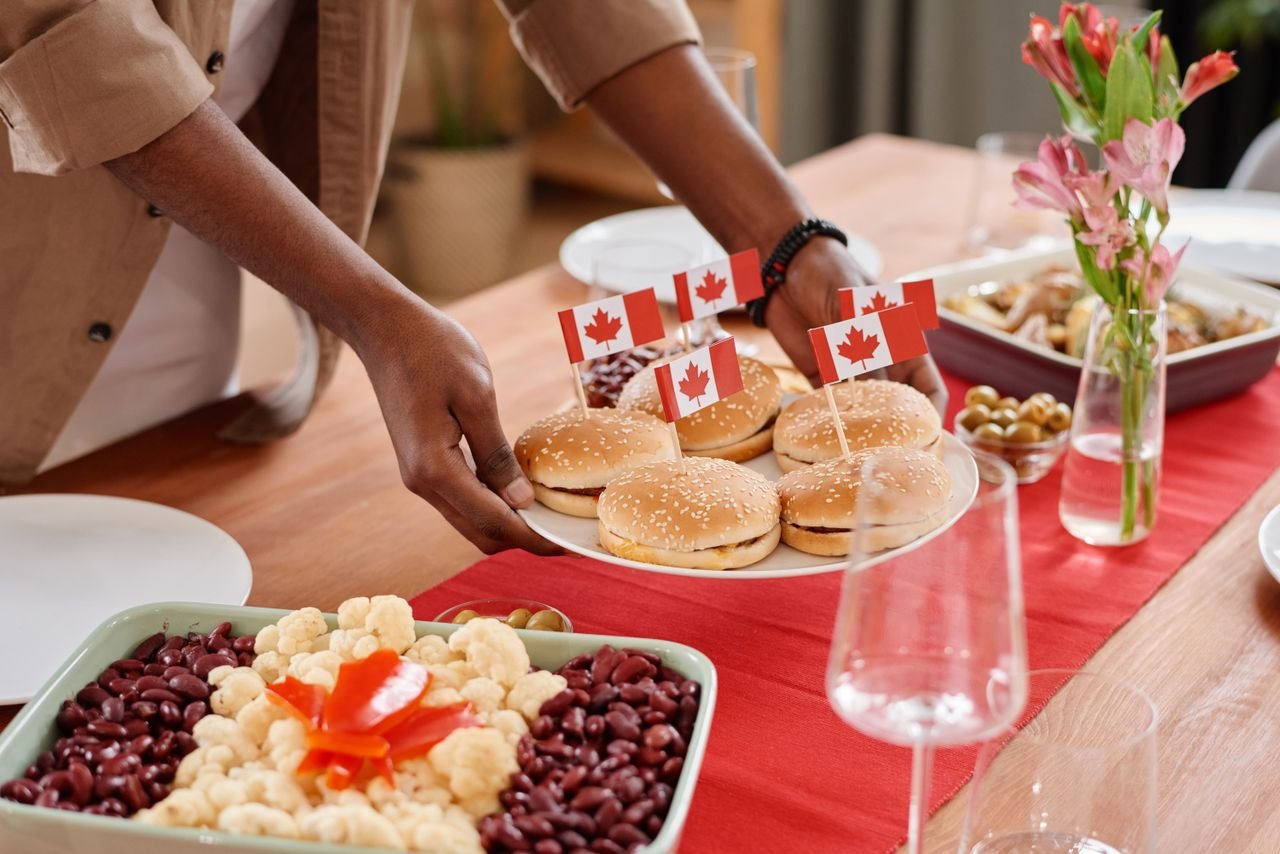 Celebrate Canada Day with delicious burgers adorned with flags, surrounded by a vibrant festive spread.