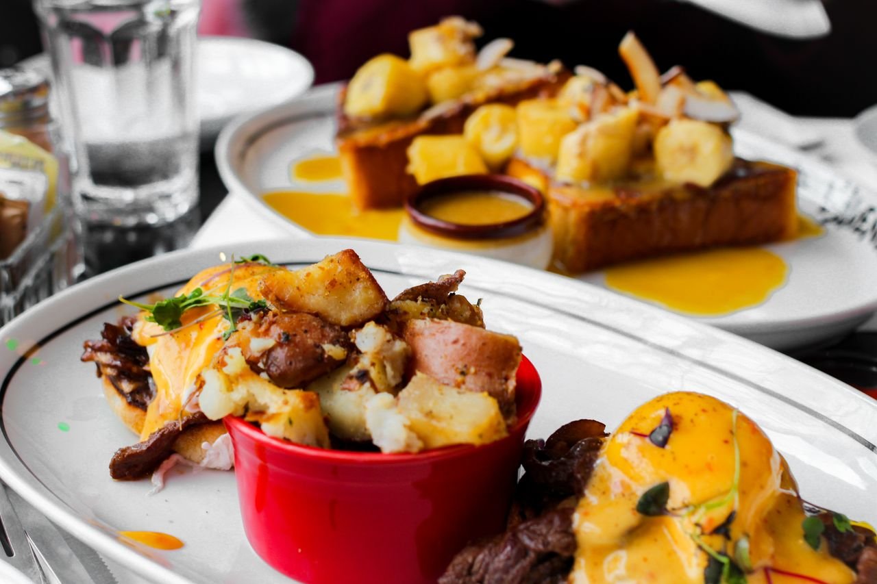 Close-up of delicious eggs benedict and banana topping toast served in Montreal cafe.